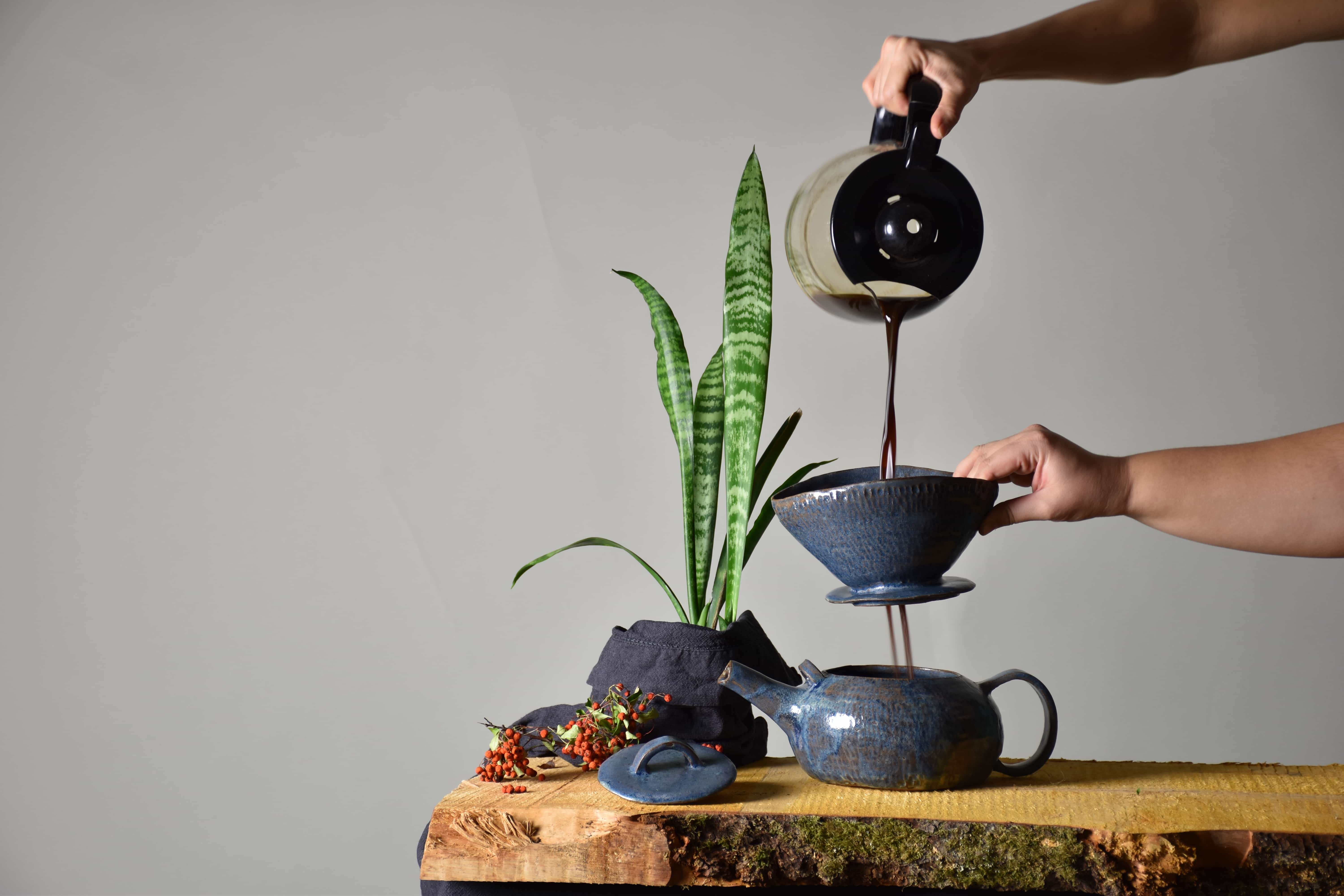picture of coffe being poured into a ceramic coffee set
